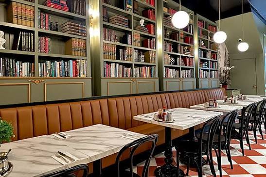 Sisterita dining room: sage bookshelves, marble tables and a checkered floor